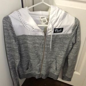 Grey zip up sweater with a hood that is waterproof